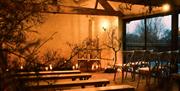 Llantilio House, Pentwyn Farm, Abergavenny barn inside at night with lights and candles very atmospheric.
