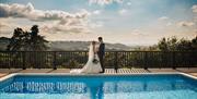 Loveseen photography captured wedding couple by swimming pool at Caer Llan in Monmouthshire