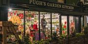The Garden Kitchen By Pugh's shop front in Abergavenny at night