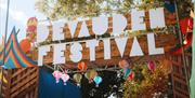 Devauden Music Festival 2025  gate with sign with bright colours and balloons in Monmouth