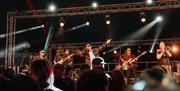 Devauden Music Festival 2025 night scene of band on stay with hands in the air