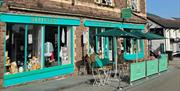 Little Green Refills - shop front - bright green wood trim on shop front and seating outside in sunshine in abergavenny