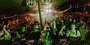 Devauden Music Festival 2025  night scene with lights and DJ set people dance in crowd