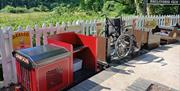 Miniature Railway at Old Station Tintern small red and black train showing a wheelchair carriage - sunny day