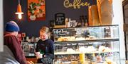 Little Green Refills - The Coffee House lady pours fresh coffee with baked cakes and food