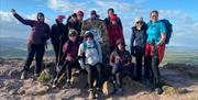 people celebrate at top of Skirrid Mountain during the Three Peaks Trial