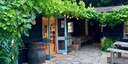 Branch and Vine in Tintern the Hop Garden showing hops growing on barn and old barrels