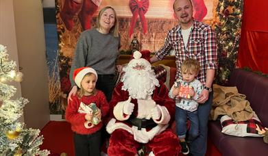 Santa at Llandegfedd Lake in Grotto with a family