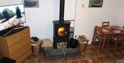 shows 43" Ultra HD tv, Charnwood B Multifuel stove (logs or anthracite) and table and 4 chairs