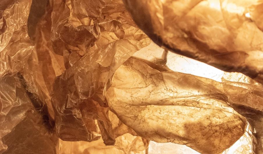 An image of brown waxed paper. It is crumpled and has areas of light and darkness.