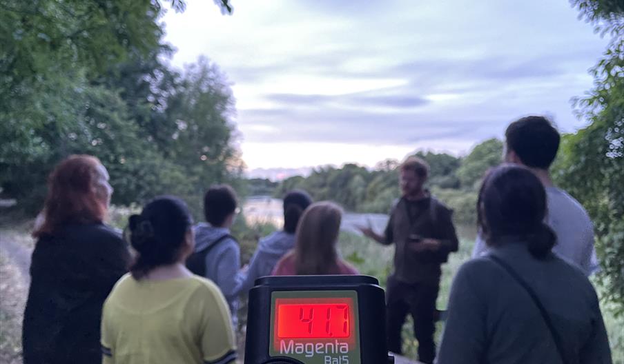 A group of people and a bat detector