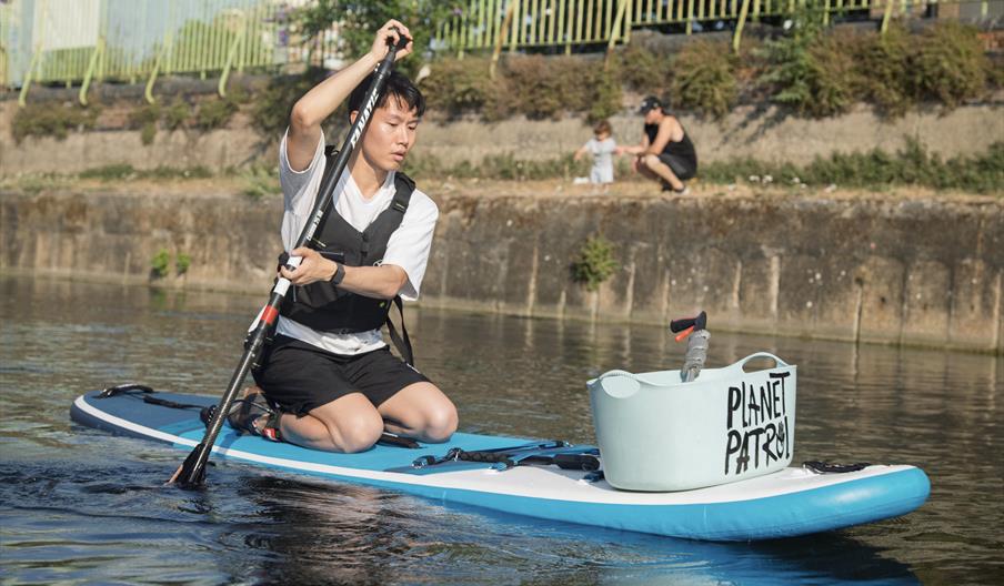 Person on a paddleboard on the river for a litter clean up