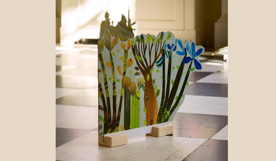 Play piece made out of card and wood on a checked marble floor