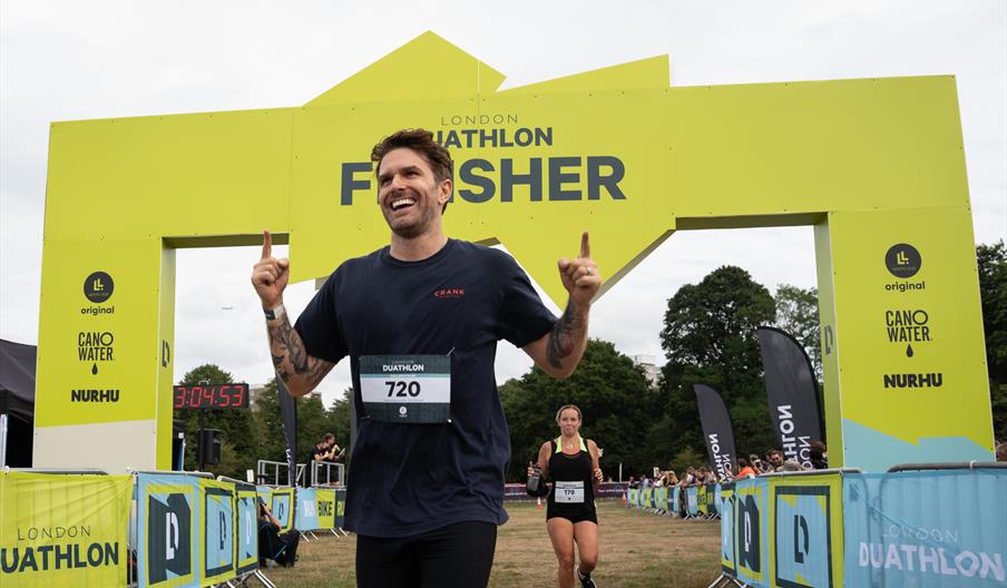 man crossing the finish line of the London Duathlon