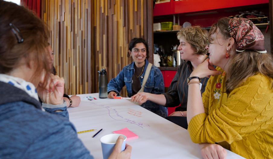A photograph of four people sat round a table