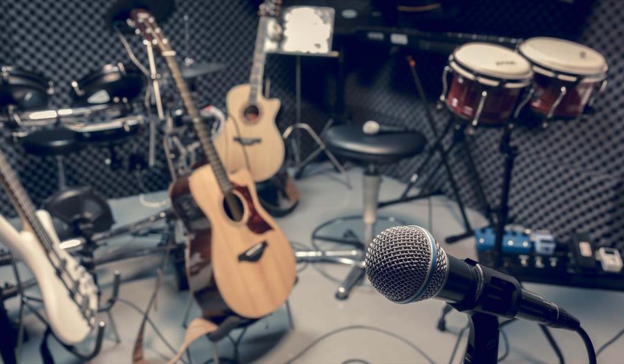 A gray-scale image of a recording studio filled with musical instruments