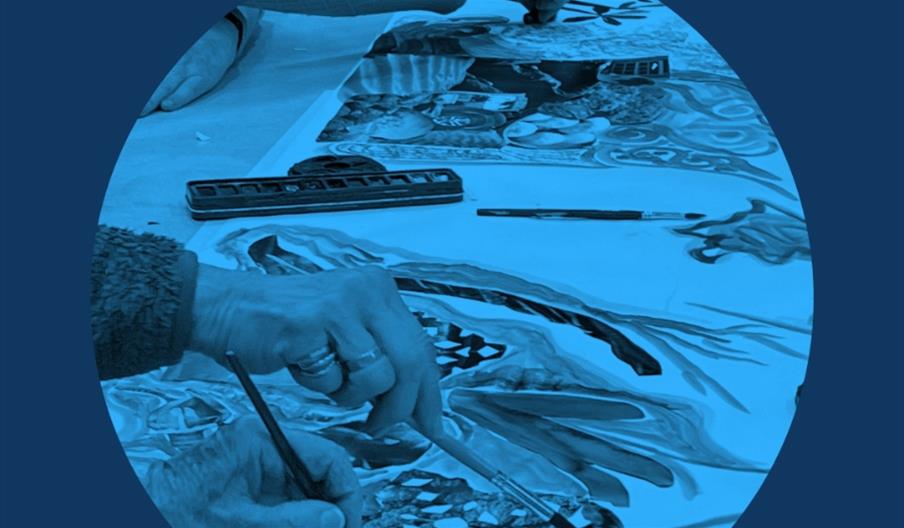 Hands working on a creative session inside a blue circle, there is a blue tint to make it look like a blue moon