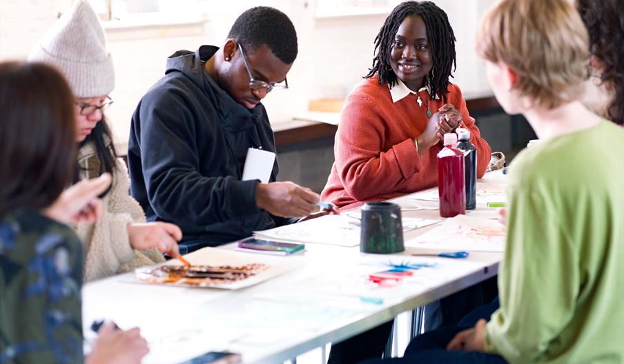 Young people sat around a table doing a creative activity