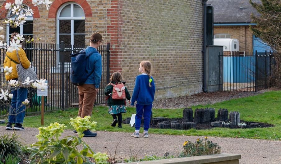 An adult and two children stand in the Orleans House Gallery grounds.