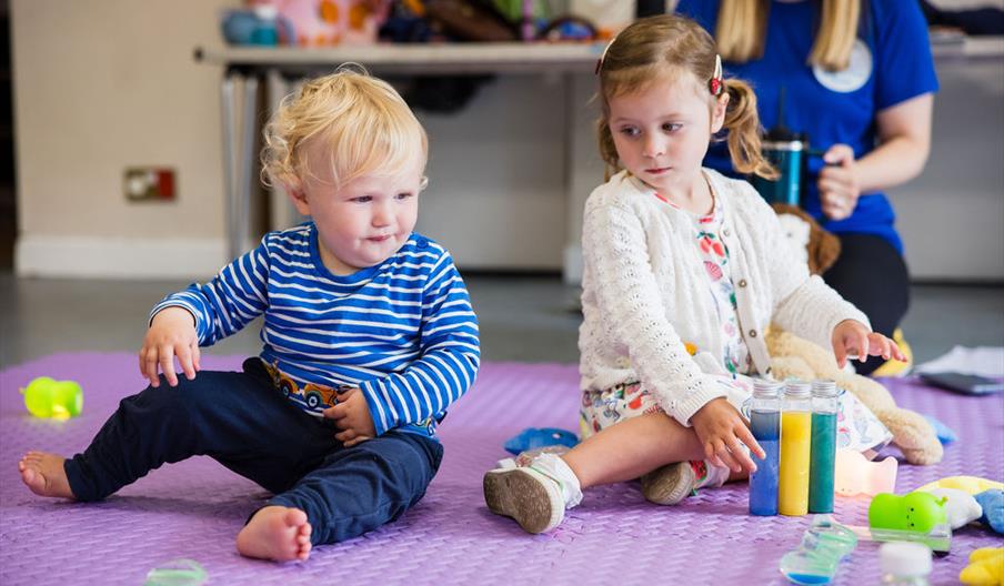 Two toddlers play on a mat at a Ways To Play Today class