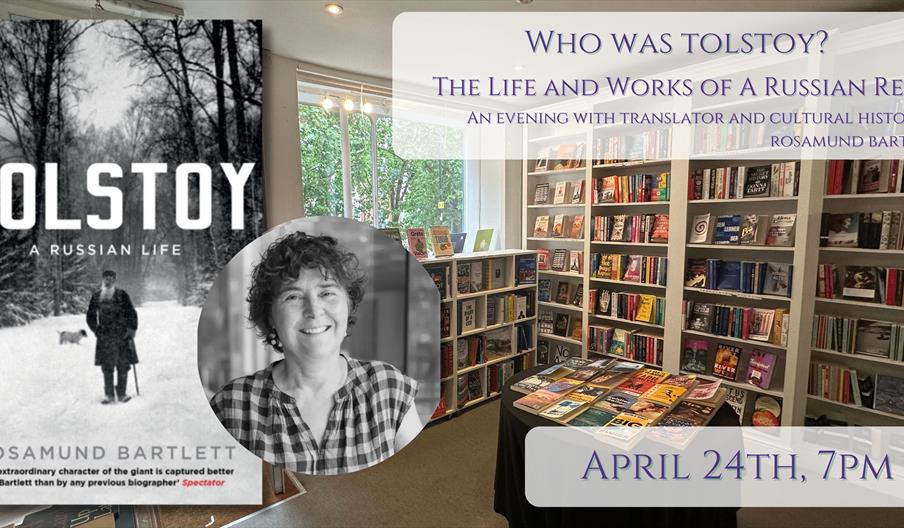 Picture of Rosamund Bartlett in front of Tolstoy: A Life bookcover in front of backdrop of the bookshop