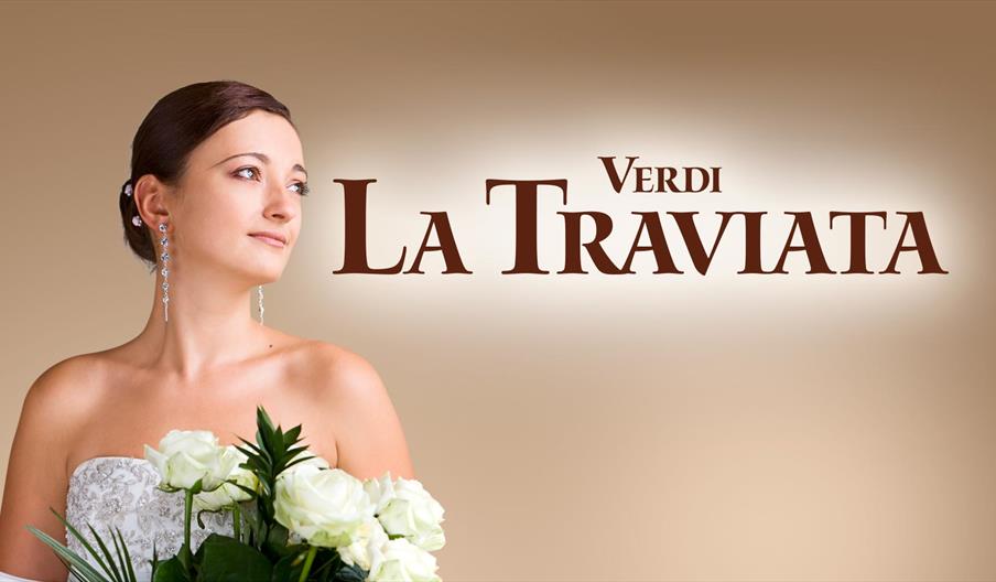 Poster for Ellen Kent's production of Verdi's La Traviata. A young brunette woman dressed in white looks to the right, holding white roses.