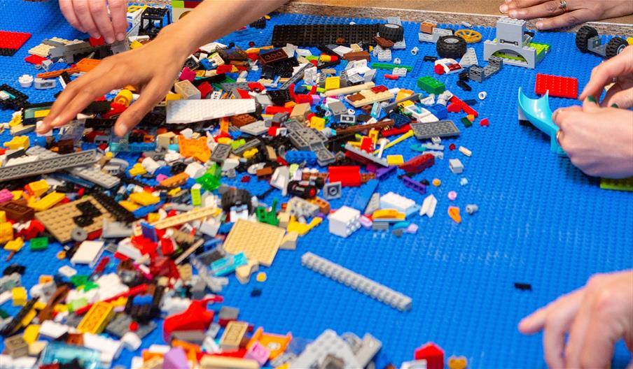 Photograph of hands using variety of lego.