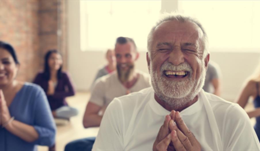 People laughing in prayer pose