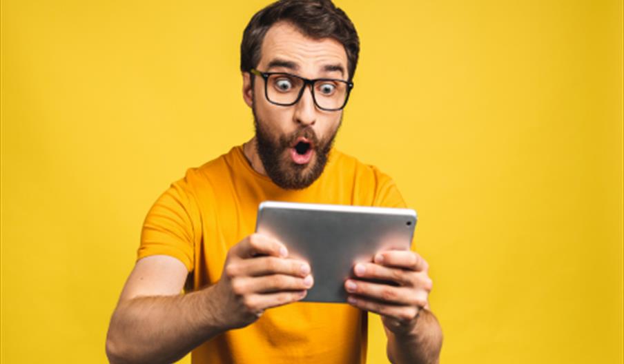 Man holding tablet with excited face