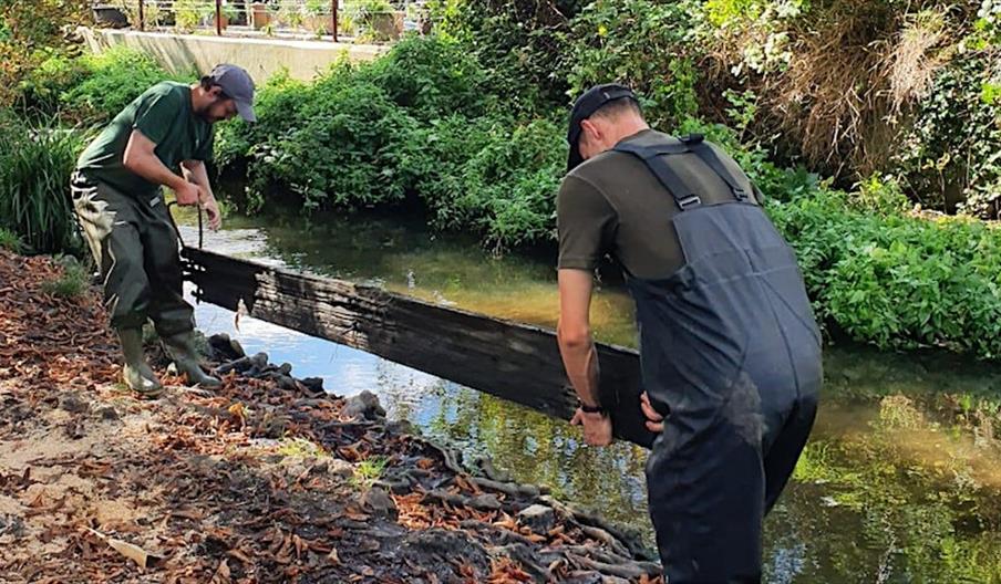 Barnes Common team members removing a toe board from the Beverley Brook