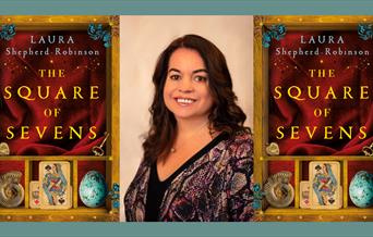 Photo of author with images of her book 'The Square of Sevens' on either side of her.