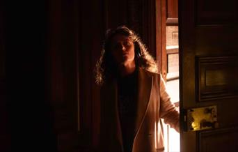 Woman opening door with headphones on