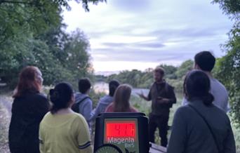 A group of people and a bat detector