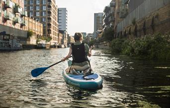 Person on a paddleboard on the river for a litter clean up