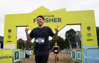 man crossing the finish line of the London Duathlon