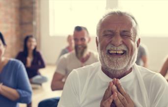 People laughing in prayer pose