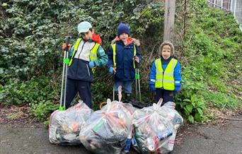 Children with litter pickers and large bags full of litter