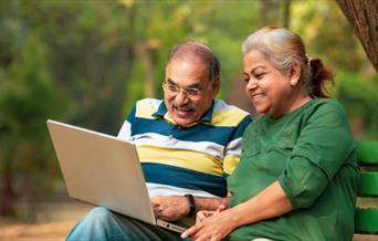 Two people looking at laptop and smiling