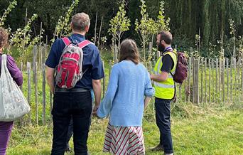 People looking at a pond and trees