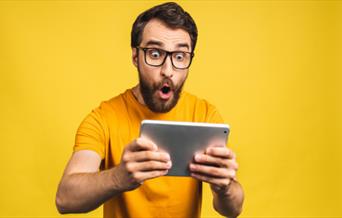 Man holding tablet with excited face