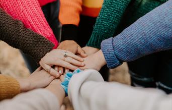Team put their hands in the middle
