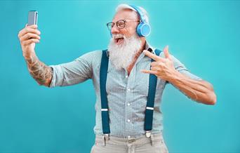 Older man looking at phone and smiling.