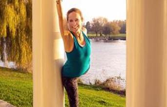 Yoga teacher Sarah Greenall, wearing a blue leotard, poses between the columns of the portico of Garrick's Temple to Shakespeare.the