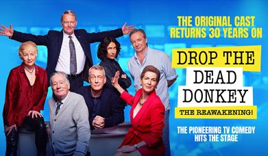 Poster for Drop the Dead Donkey. The original cast poses together on a news desk, to the left of the following text: The original cast returns 30 year