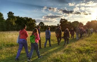 People walking westward on a grassy path. Photo by Andrew Wilson.