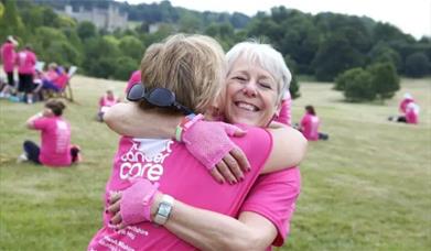 Pink Ribbon Walk - Two ladies in pink hugging in a park