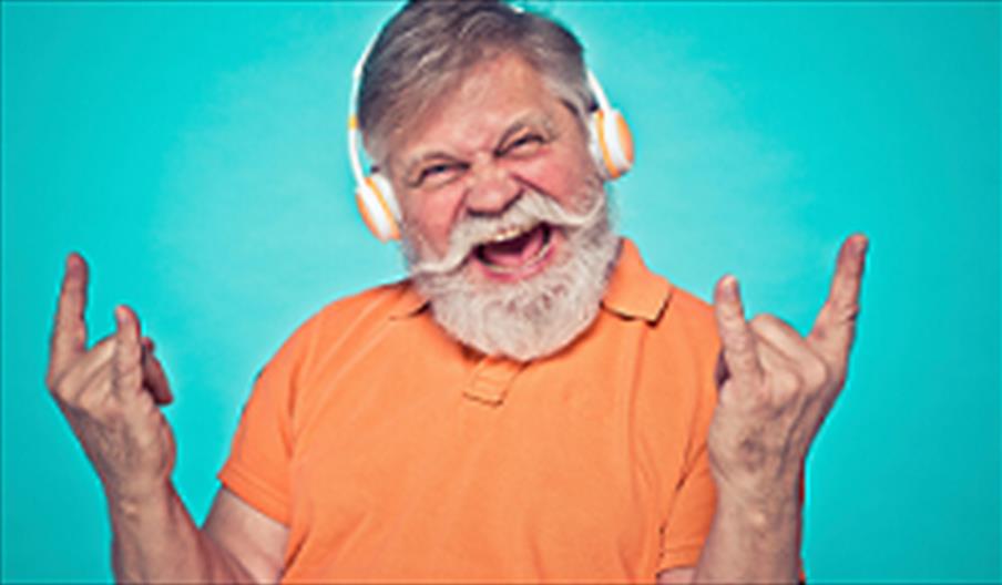 Older man with headphones rocking out to music.