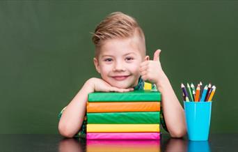 kid smiling, books, pensils