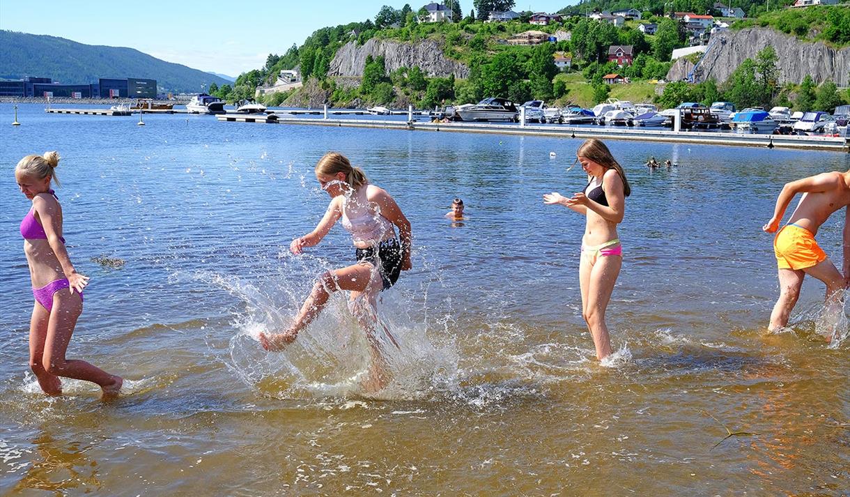 4 ungdom leker i vannet ved Bystranda og Nesøya Marina, i Notodden. Foto