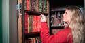 lady looks at books on a bookshelf at Sondre Brekke main farm in Skien